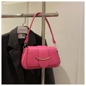 Détail du sac rose vif à texture croco avec boucle métallique dorée en demi-lune