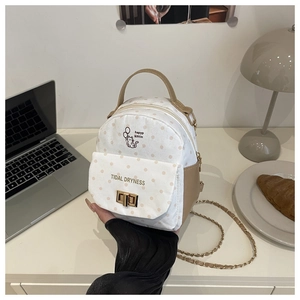 Detail of polka dot mini backpack with cat print and chain strap in casual setting