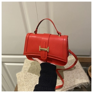 Detail der roten gesteppten Handtasche mit goldener Schnalle und Ledertextur