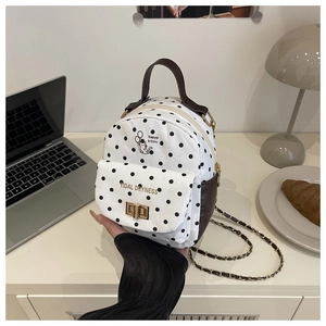 Polka dot mini backpack featuring chain straps and a cat print in a cozy lifestyle setting