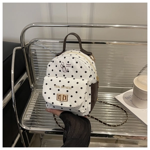 Close-up of polka dot mini backpack with golden metal twist lock and cartoon cat print