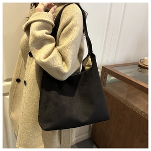 Black suede hobo bag shown with a wool coat for a stylish high-capacity shoulder look