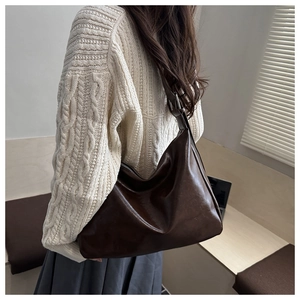 Détail du sac fourre-tout en cuir marron foncé avec boucle argentée et zip métallique