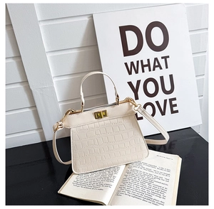 Detalle del bolso Kelly blanco roto con relieve de cocodrilo, cierre dorado y bandolera