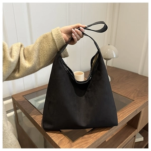 Detail shot of black suede tote bag in minimalist style with large capacity shoulder strap