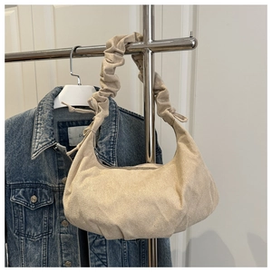 Detail of beige suede hobo bag with unique ruched handle and elegant tie ribbon decor