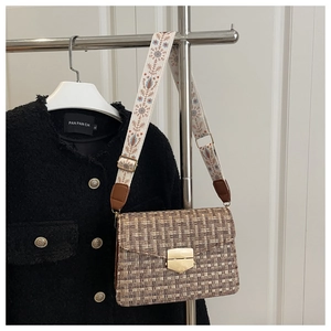 Detail of retro tweed bag with golden shield clasp and floral patterned wide strap