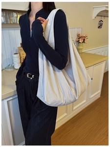 Detail view of large beige nylon tote bag showing textured fabric and lightweight drape