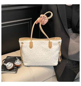 Detail of white faux shearling tote bag with contrasting tan leather straps for winter