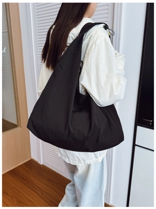 Detail shot of the large capacity black nylon tote bag showing lightweight fabric and volume