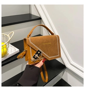 Detail of caramel leather shoulder bag with matte texture and white V-shaped stitching