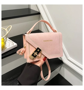 Detail of pink leather handbag with gold lock and Fashion & Bags text on steps
