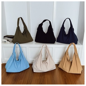 Detailed display of six large capacity nylon tote bags in diverse earth tone colors