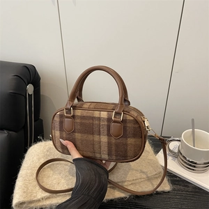 Fashionable plaid bowling bag with brown leather handles and golden hardware