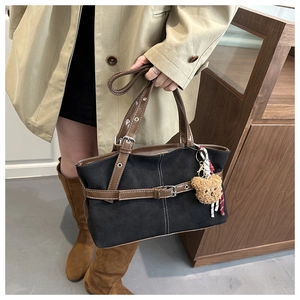 Dettaglio della grande borsa tote vintage con manici in pelle marrone e ciondolo