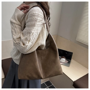 Detail of coffee brown oversized tote bag showing textured soft leather and vintage folds