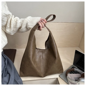 Detail of soft brown PU leather tote bag showing fine grain and sturdy stitching
