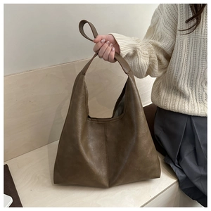Detail of dark brown leather hobo bag with vertical stitching for autumn winter