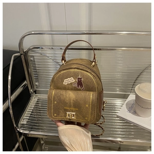 Détail du sac à dos chat rétro marron avec texture vintage et fermoir doré métallisé