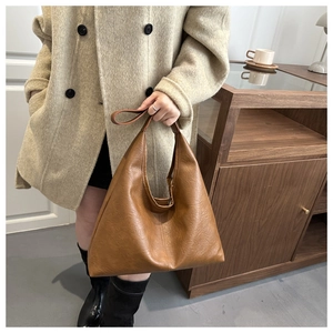 Close-up of caramel leather tote bag detail with soft texture and refined stitching