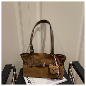 Dettaglio della borsa tote in pelle scamosciata marrone con cintura e fibbia argento