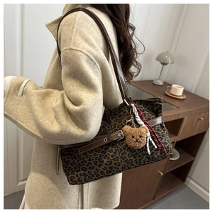 Leopard print suede tote bag detail with brown faux leather strap and plush bear charm