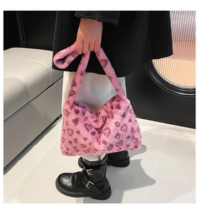 Détail du sac bandoulière en peluche rose avec motifs de cœur léopard et sangle large