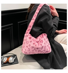 Gros plan du sac bandoulière rose en fausse fourrure léopard avec un manteau d'hiver noir