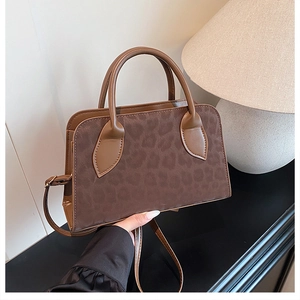 Detail of vintage brown tote bag with leopard print texture and adjustable shoulder strap