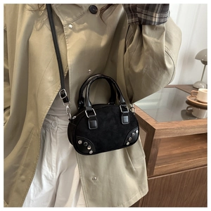 Detail of black suede hobo bag with silver studs and adjustable shoulder strap