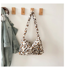 Gros plan du sac hobo en fausse fourrure léopard avec écouteurs et veste en jean