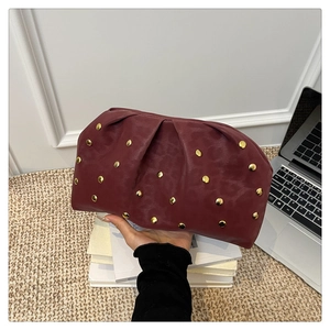 Detail of burgundy pleated cloud clutch featuring gold studs and leopard texture