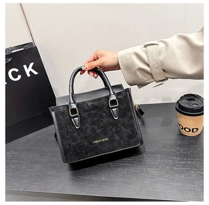 Vue détaillée du sac vintage noir avec boucle en métal doré et texture cuir mat