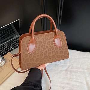Brown tote bag with leopard print panel and adjustable strap in a daily office setting