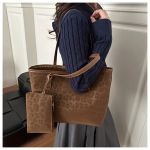 Detailed view of leopard print tote bag with matching zipper pouch and suede texture