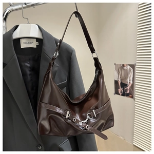 Detail of dark brown glossy leather dumpling bag with silver hardware and retro pleats