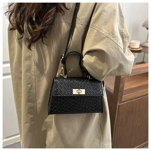 Detail of black snake pattern Kelly bag with gold twist lock and fine shoulder strap