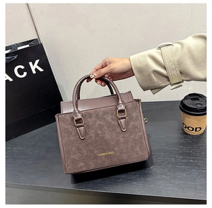 Détail du sac à main marron vintage avec boucles dorées et texte de mode élégant