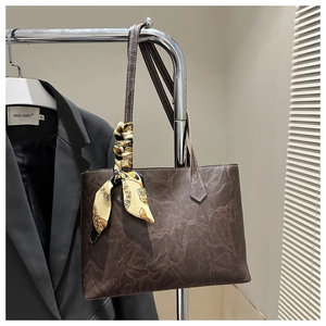 Detail of brown tote bag with vintage wrinkled leather and elegant silk scarf accessory