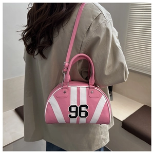Pink and white bowling bag with number 96 patch shown on a model for Y2K style fashion