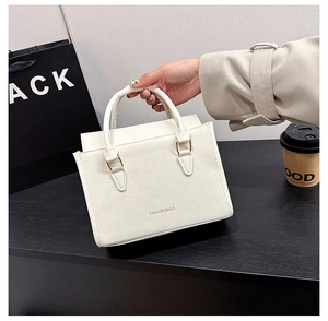 Détail d'un sac cabas structuré blanc avec texte FASHION BAGS et boucles dorées