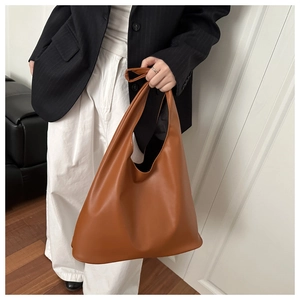 Close-up of brown leather tote bag showing smooth texture and large capacity design