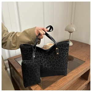 Detail of leopard print tote bag and pouch set with leather handles and gold rivets