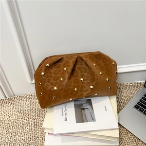 Brown leopard print ruched cloud bag with gold studs on a stack of notebooks