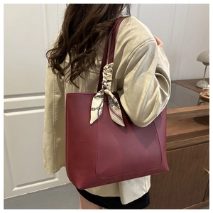 Vue latérale du grand sac cabas bordeaux en cuir avec foulard en soie sur l'anse