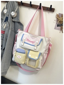 Close-up of a multi-pocket canvas tote bag with pink straps and colorful compartments