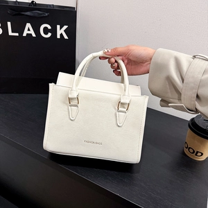 Sac à bandoulière minimaliste crème avec détails dorés et lettrage tendance