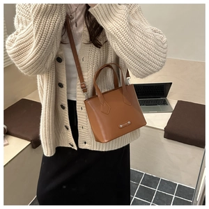 Klassische braune Lederbeuteltasche als Umhängetasche an einem Model in gemütlicher Szene