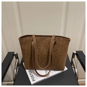 Detailed view of leopard print tote bag texture and straps on a lifestyle backdrop
