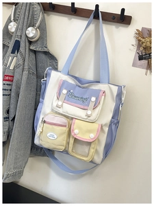 Close-up of multi-pocket canvas tote with pastel color blocks and detailed embroidery